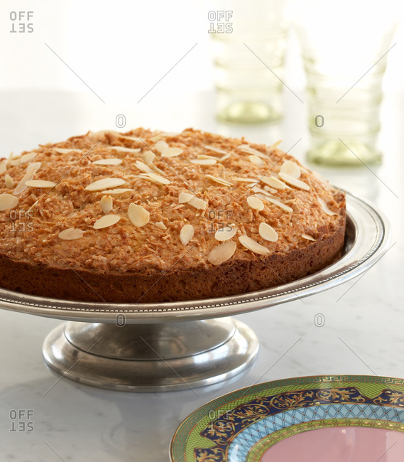 Coconut macaroon cake with almond flakes on cake stand