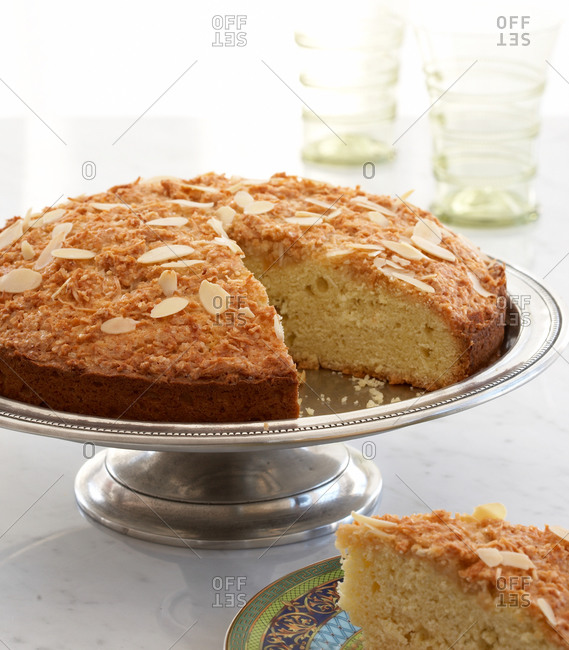 Coconut macaroon cake with almond flakes on cake stand