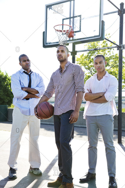 Three african american men in business suit standing on basketball court