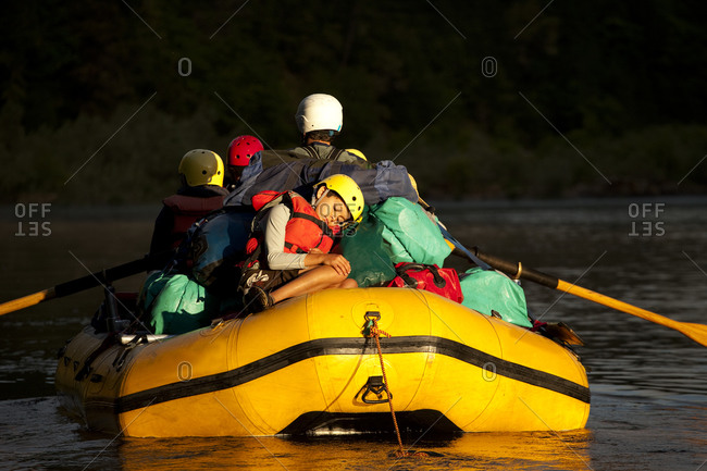 One boy sleeping on the back of a raft in golden light.