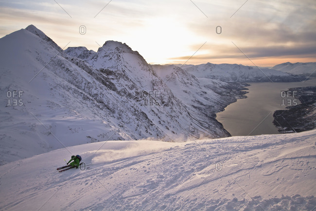 Norway, Lyngen, Skier skiing downhill at sunset