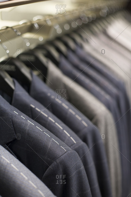 Close up of suit jackets hanging in a row
