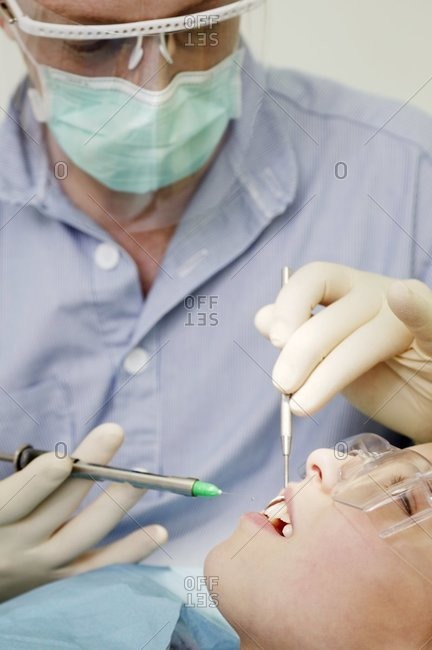 Dentist injecting into a girl\'s gum