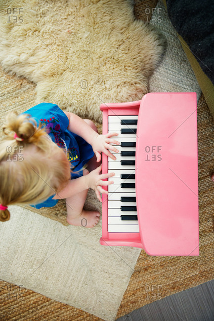 Little girl playing with toy piano