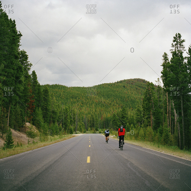 Rear view of two people cycling on a road, Rocky Mountain National Park, Colorado, USA