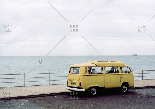Yellow van parked by sea