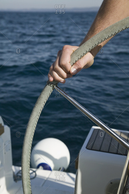 Detail of a man at the helm of a yacht