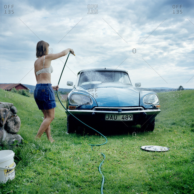 Woman washing vintage car