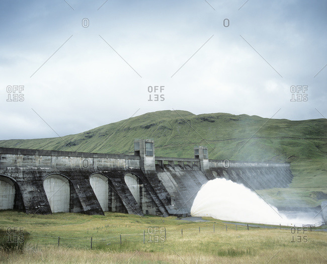 Hydroelectric dam. Water flowing out of the base of a dam at a hydroelectric power station, Perthshire, Scotland, UK.