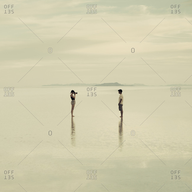 Man and woman standing on the flooded Bonneville Salt Flats