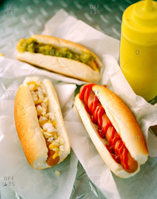 Three hot dogs with different condiments