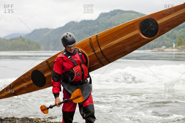 A man carrying  his cedar strip kayak