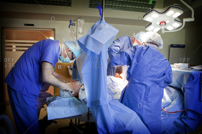 Anesthesiologist interacting with patient to ensure patient maintains hypnotic state during cesarean section