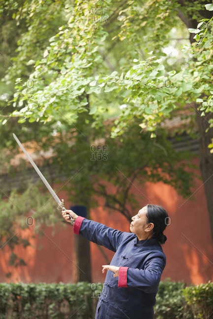 Older Chinese man practicing taiji in park