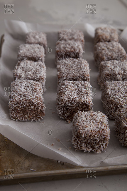 Squares of sponge cake coated chocolate icing and coconut flakes