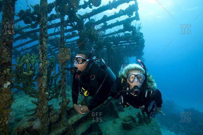 Couple scuba diving in wreckage