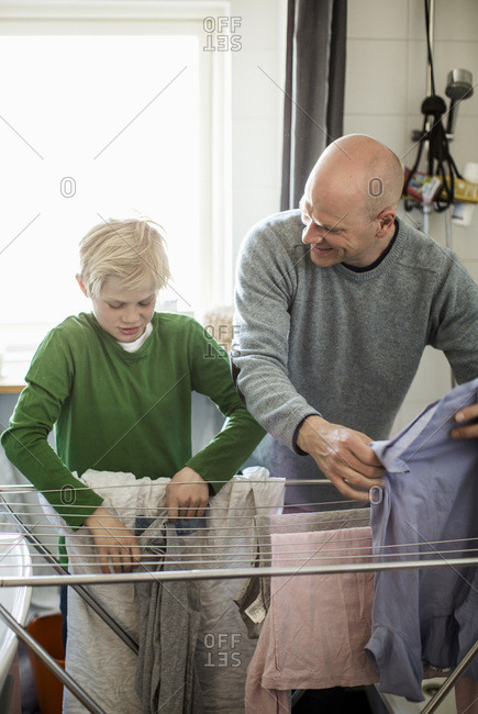Father and son drying laundry on rack