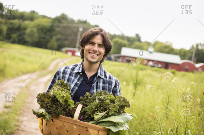 Man posing with vegetables on organic farm