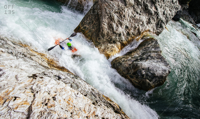 Overhead view of a kayaker coming out of a narrow rapid
