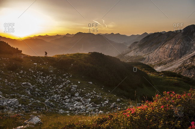 Man hiking through Niedere Tauern mountains at sunrise