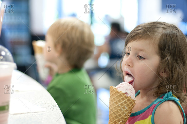A 2 year old girl eating an ice cream