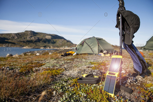 Solar charger with tent in background at campsite