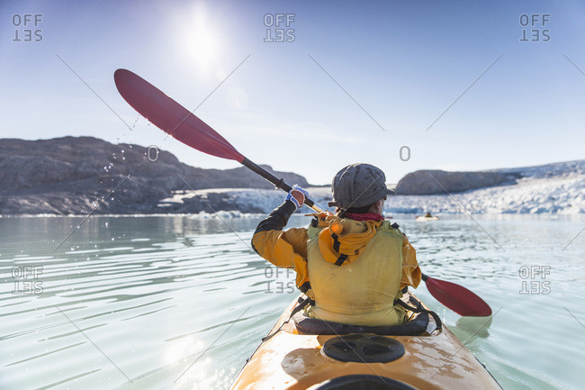 Rear view of mature woman kayaking on sea
