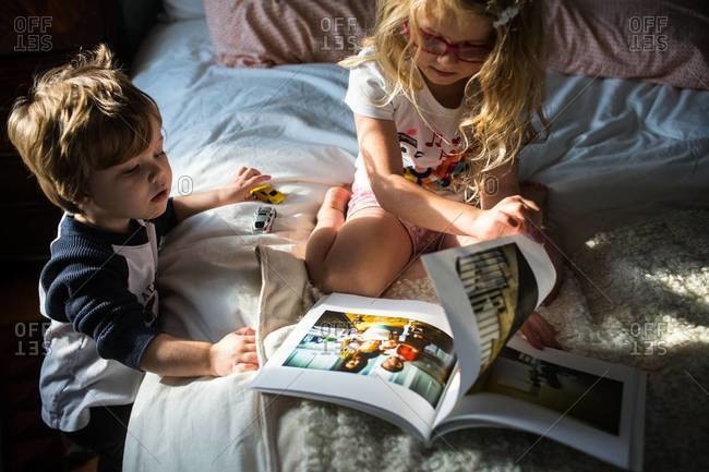 A brother and sister flipping through a book