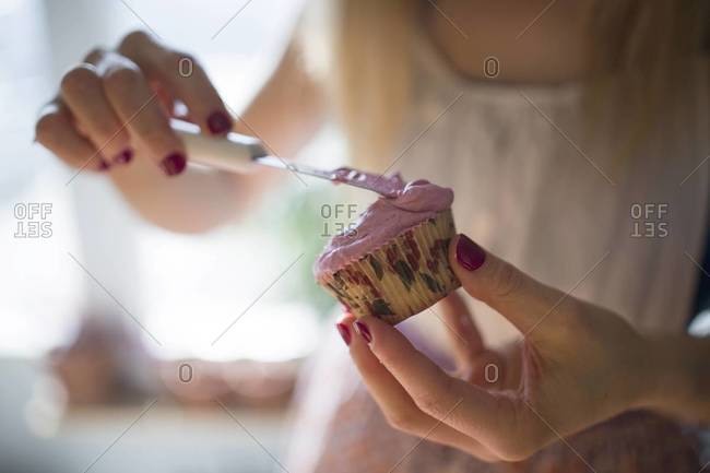 A woman prepares cupcakes