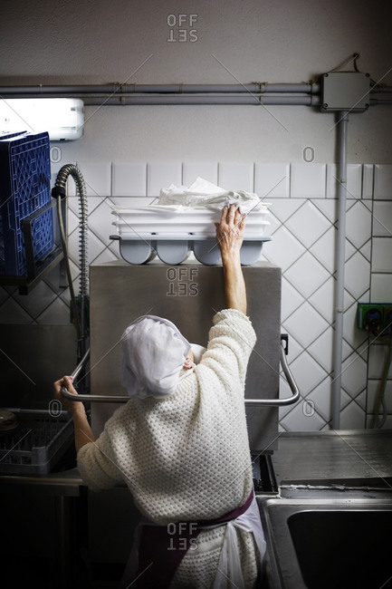 Woman reaching for a kitchen towel in an industrial kitchen