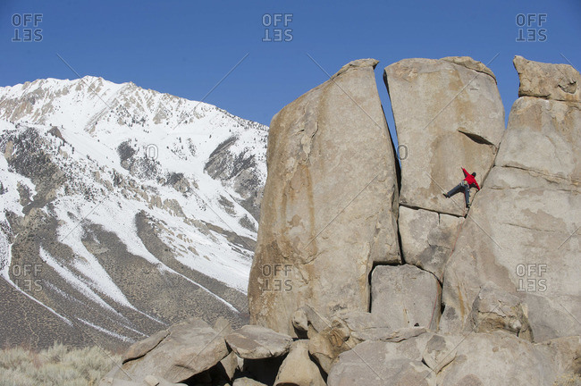 A man climbs a boulder in Bishop, California