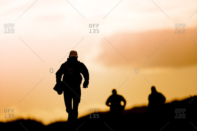 Group of outdoor runners silhouette against sunset sky