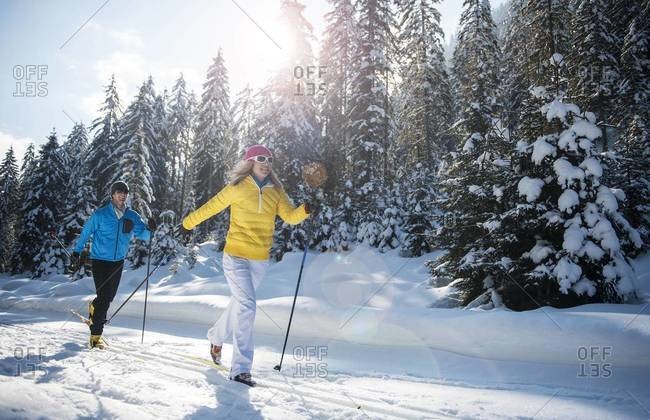 Young couple cross-country skiing on trail