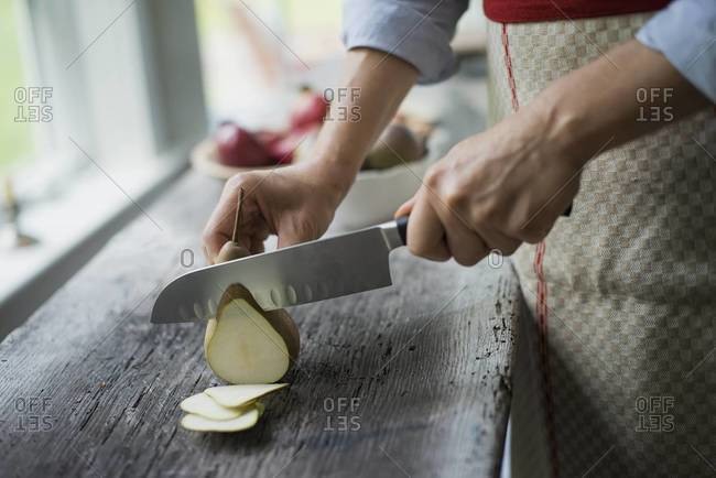 Person cutting up an organic pear