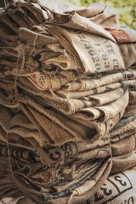 Pile of empty stamped hessian sacks bundled up for reuse or recycling, in a coffee processing plant