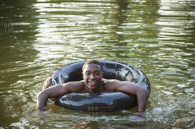 Teenager floating in the water using a swim float