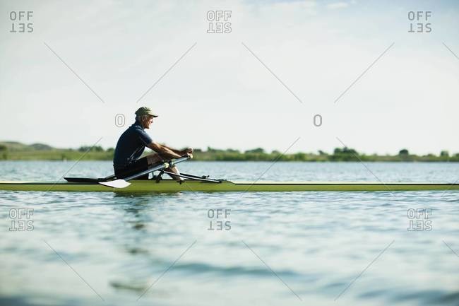 Side view of man rowing on a lake