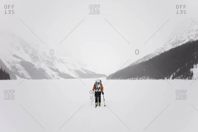 Skier crossing a frozen lake on the Wapta Traverse in Alberta, Canada
