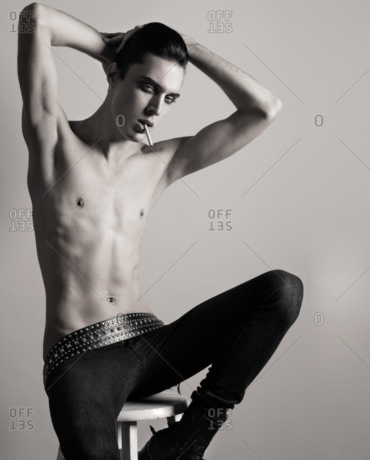 Androgynous male model sitting on a stool