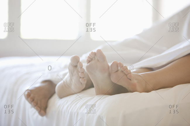 Close up of couple\'s feet in bed