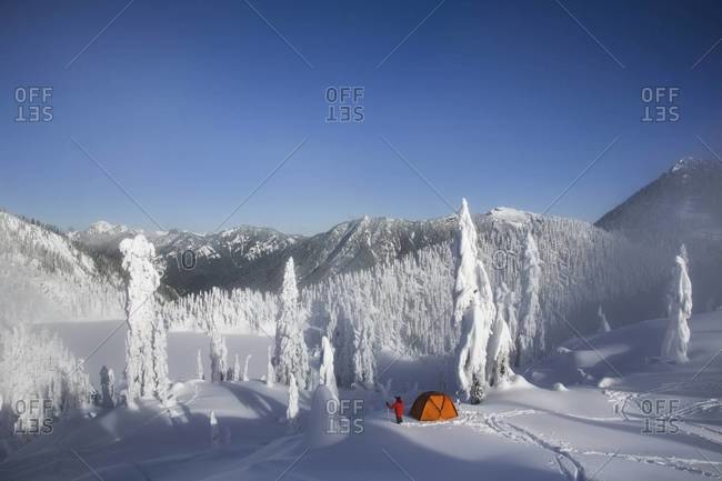 Michael Hanson walks through deep powder to his campsite in the snow covered Cascade Mountains overlooking Snow Lake.