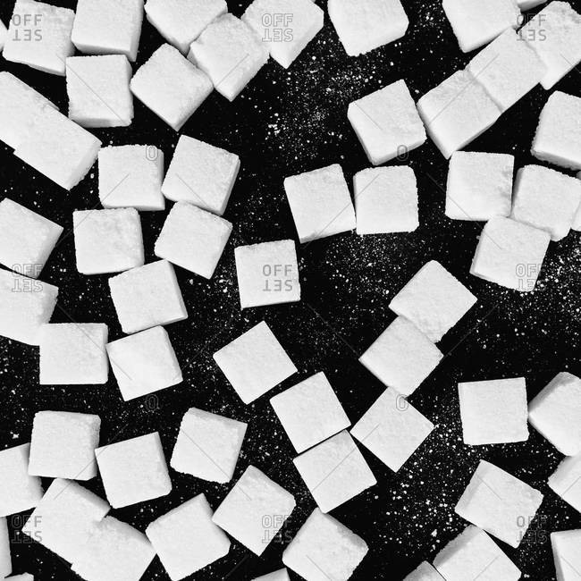 Overhead view of sugar cubes on black backdrop