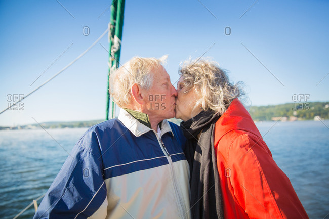 Mature couple kissing on sailing boat