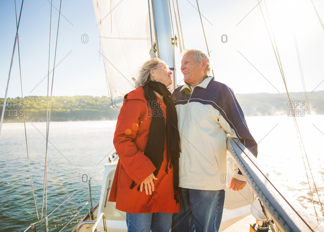Mature couple embracing on board of sailing boat