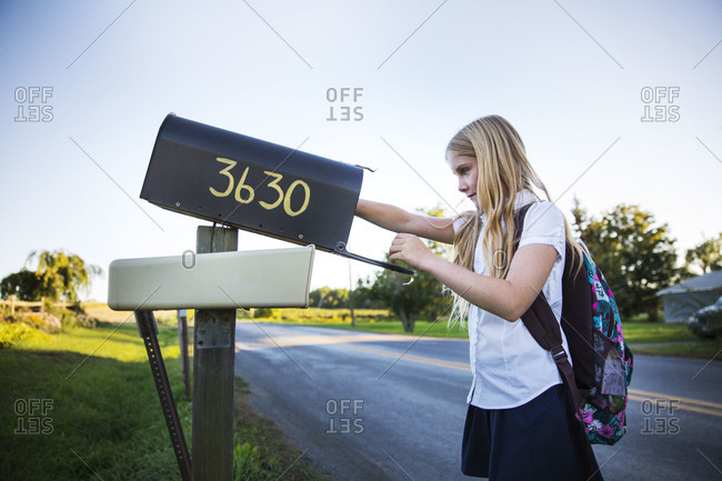 Young girl checking letter box