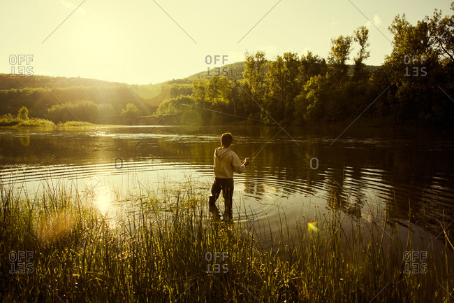Man fishing in still lake