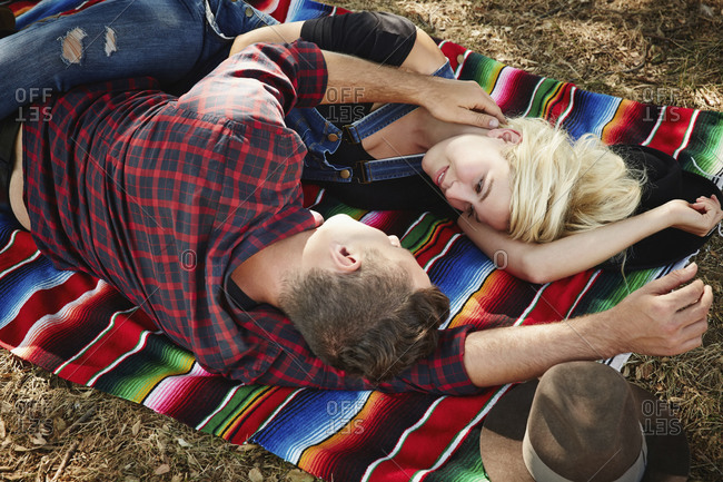 Couple laying on blanket in park