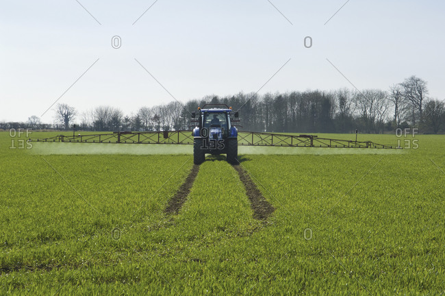 Tractor and crop-sprayer in field