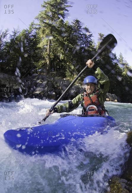 Woman kayaking rough waters