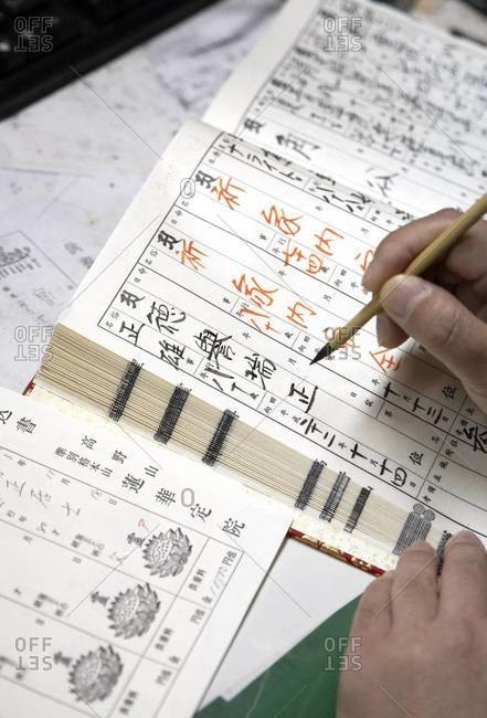 Close up of man writing with a bamboo pen